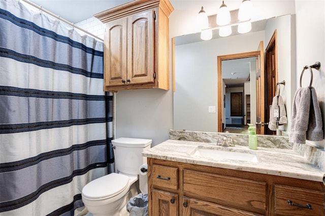 full bath featuring toilet, vanity, and a shower with curtain