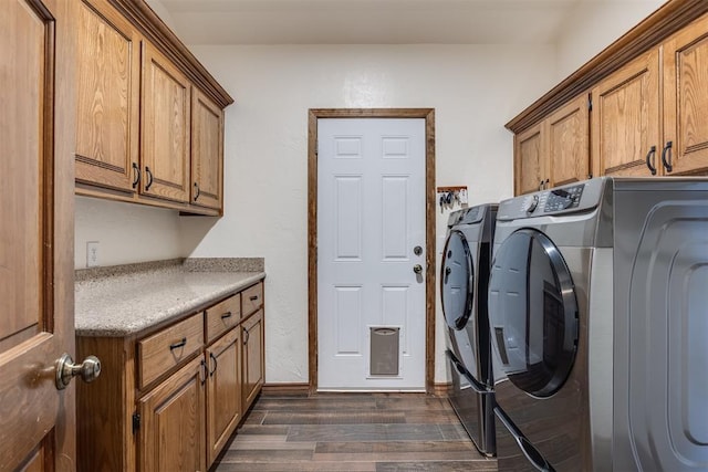 laundry room featuring dark wood-style floors, cabinet space, and washing machine and clothes dryer