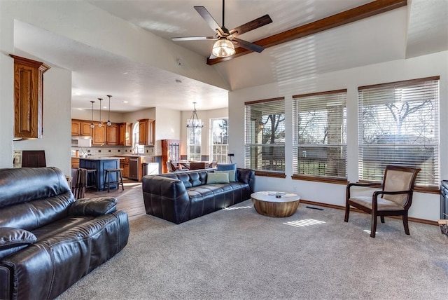 living area featuring baseboards, carpet floors, and ceiling fan with notable chandelier