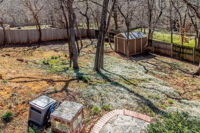 view of yard with a storage shed, a fenced backyard, and an outdoor structure