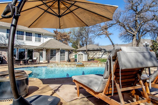 pool featuring fence, an outbuilding, a storage shed, and a patio area