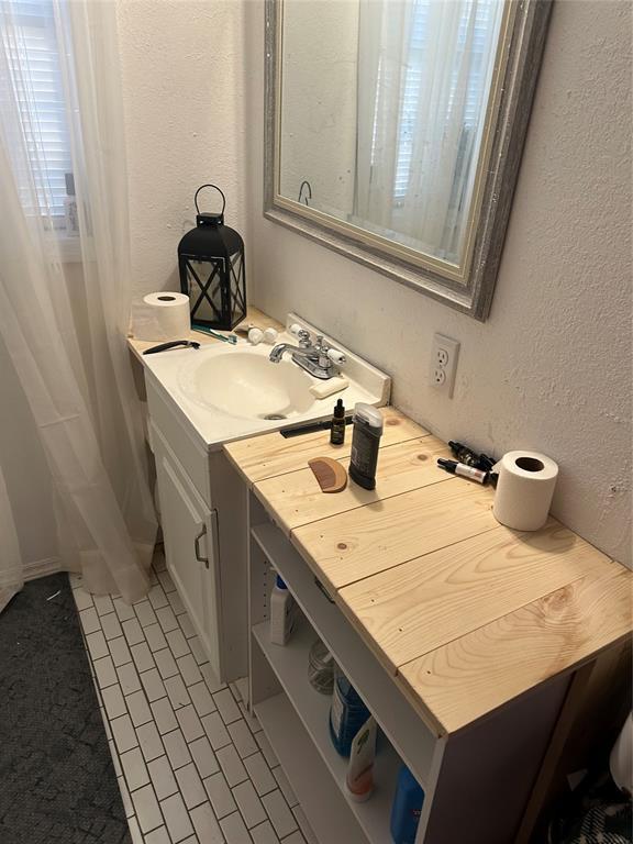 bathroom with vanity and a textured wall