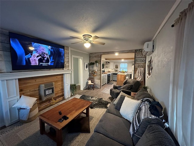 living area featuring light wood-type flooring, an AC wall unit, a fireplace, crown molding, and ceiling fan