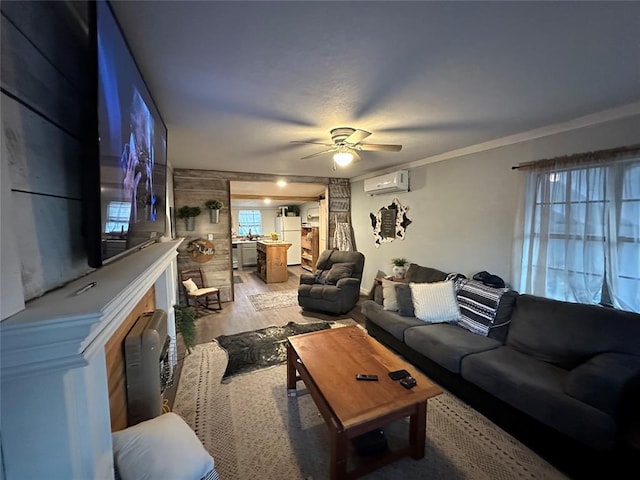 living area featuring light wood-type flooring, an AC wall unit, and a ceiling fan