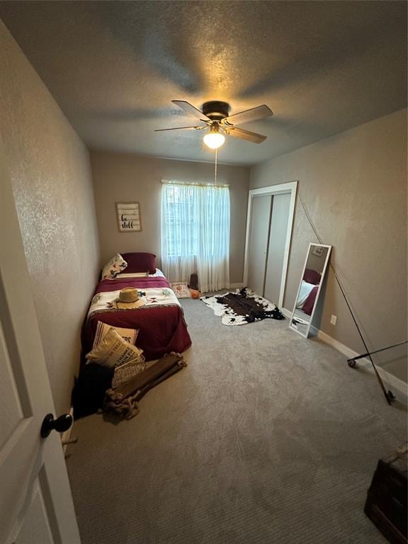 carpeted bedroom featuring a ceiling fan, a closet, and a textured ceiling