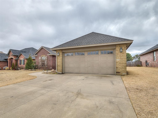 view of front of home featuring driveway, stone siding, fence, a front yard, and a shingled roof