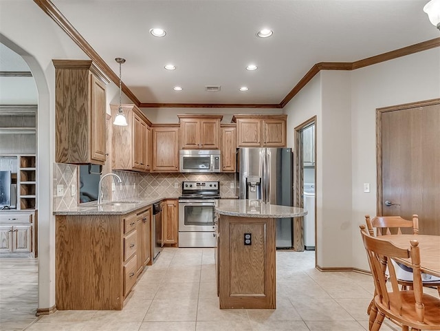 kitchen featuring a sink, light stone countertops, appliances with stainless steel finishes, and washer / clothes dryer