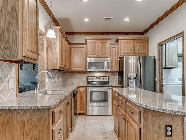 kitchen with visible vents, a sink, light stone counters, washer / clothes dryer, and appliances with stainless steel finishes