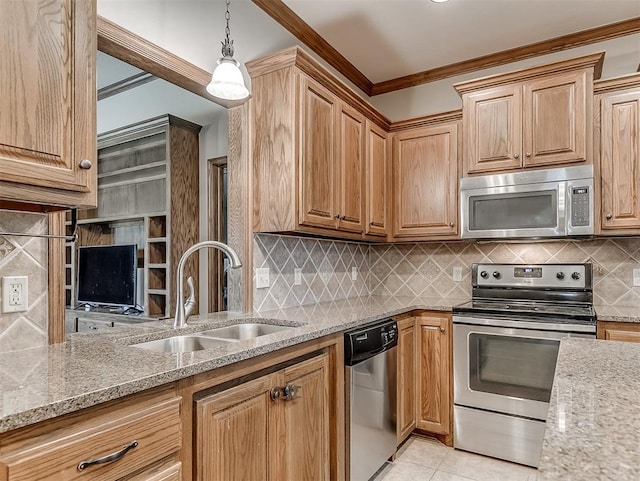 kitchen with a sink, stainless steel appliances, light stone countertops, and ornamental molding