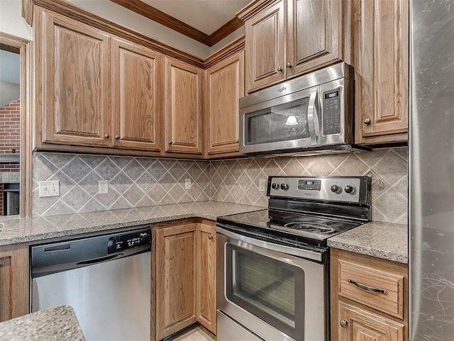 kitchen featuring light stone counters, tasteful backsplash, appliances with stainless steel finishes, and crown molding