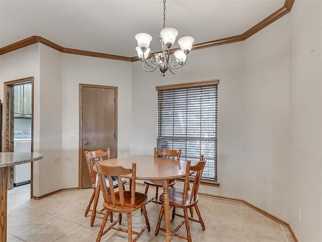 dining space featuring crown molding, baseboards, a chandelier, light tile patterned floors, and washer / clothes dryer