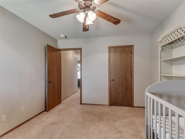 bedroom with light carpet, ceiling fan, and baseboards