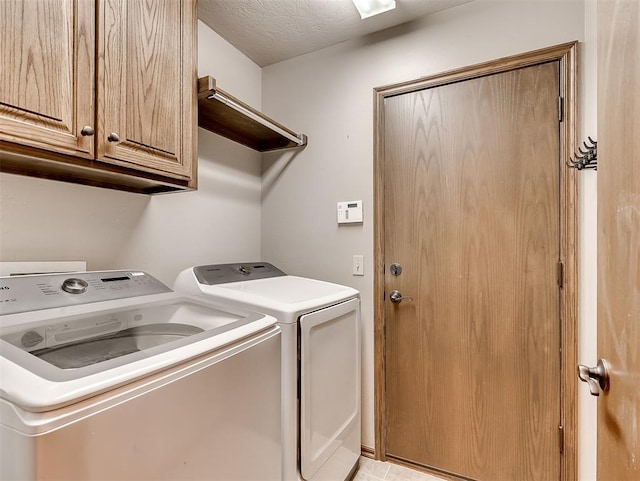 clothes washing area with cabinet space, independent washer and dryer, and a textured ceiling