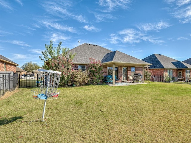 back of property featuring a patio, roof with shingles, a yard, a fenced backyard, and brick siding