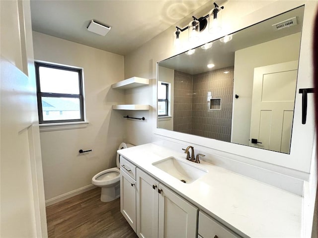 bathroom featuring visible vents, toilet, wood finished floors, baseboards, and vanity