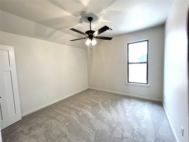 spare room featuring visible vents, light colored carpet, baseboards, and ceiling fan