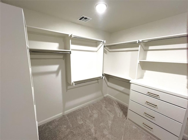 spacious closet featuring light colored carpet and visible vents