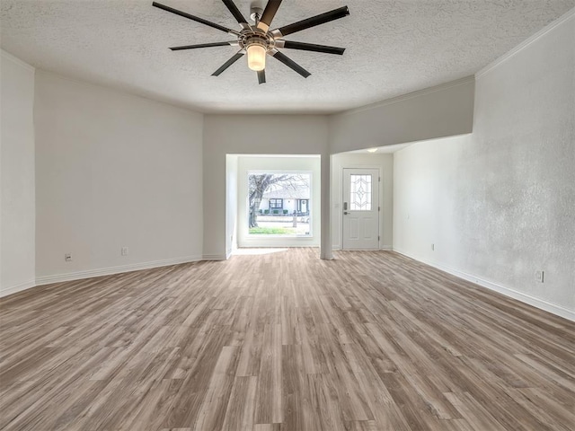 unfurnished living room with a ceiling fan, wood finished floors, baseboards, and a textured ceiling