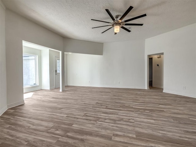 unfurnished room with baseboards, a textured ceiling, a ceiling fan, and wood finished floors