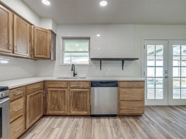 kitchen featuring a wealth of natural light, a sink, open shelves, stainless steel appliances, and light wood-style floors