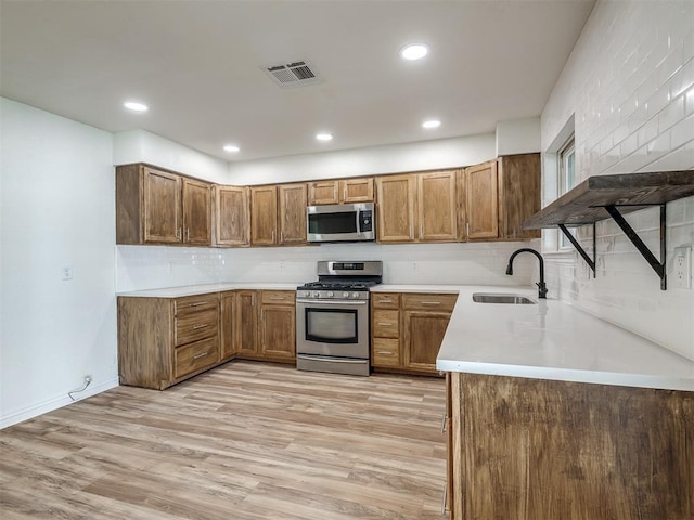 kitchen featuring visible vents, light wood-type flooring, appliances with stainless steel finishes, and a sink