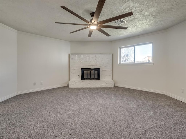 unfurnished living room featuring carpet, ornamental molding, a fireplace, and a textured ceiling