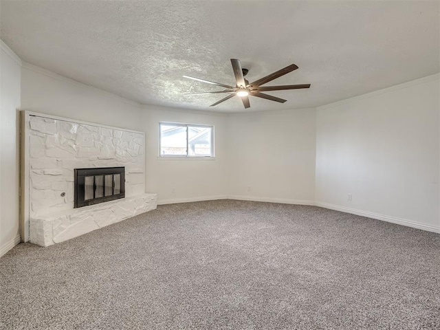 unfurnished living room featuring crown molding, baseboards, carpet flooring, a fireplace, and a textured ceiling