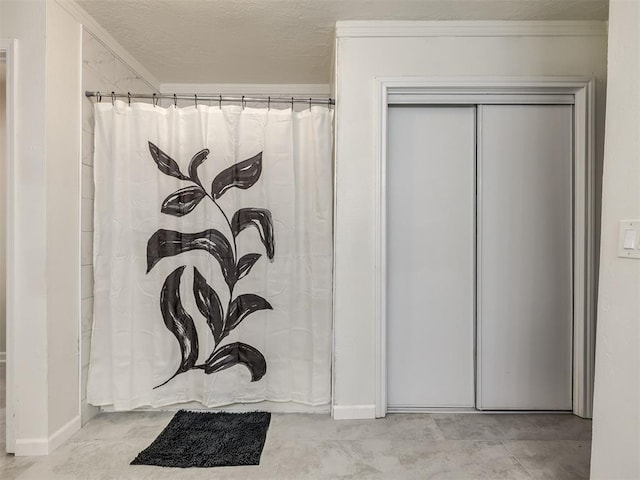 full bath with a textured ceiling, crown molding, and a shower with curtain