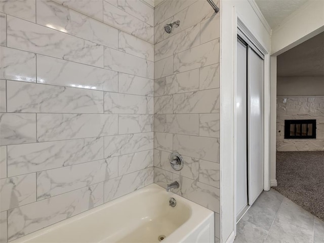 bathroom featuring a glass covered fireplace and shower / tub combination