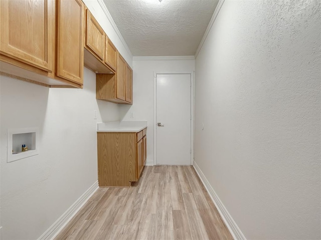 laundry area featuring baseboards, light wood finished floors, cabinet space, washer hookup, and a textured ceiling