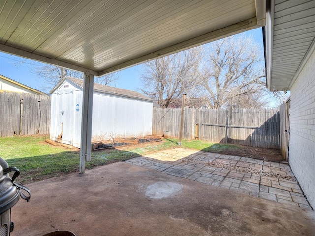 view of patio / terrace with an outbuilding, a storage shed, and a fenced backyard