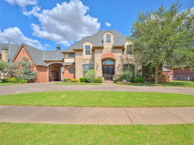 french country inspired facade featuring stone siding, a chimney, and a front lawn