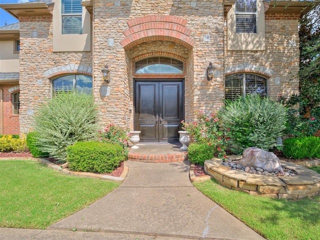 entrance to property featuring stone siding and stucco siding