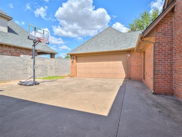 exterior space with concrete driveway and fence