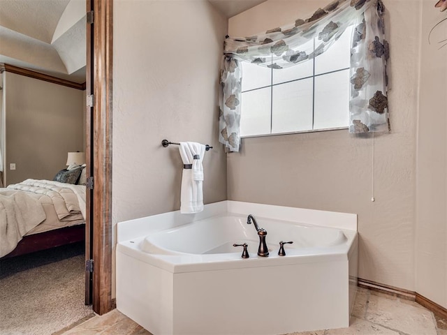 ensuite bathroom with a garden tub, baseboards, and connected bathroom