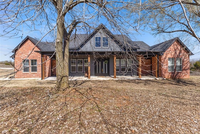 view of front of property featuring brick siding and a shingled roof