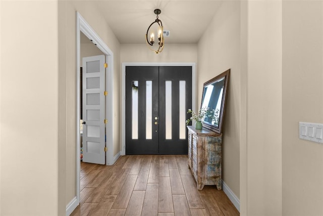 entrance foyer featuring visible vents, wood finished floors, and baseboards