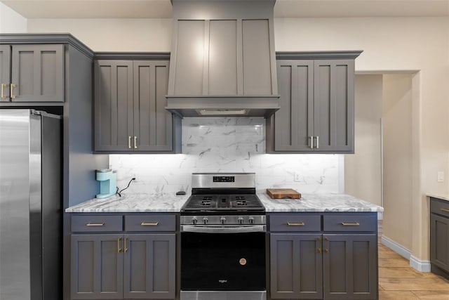 kitchen with custom range hood, gray cabinetry, tasteful backsplash, and stainless steel appliances