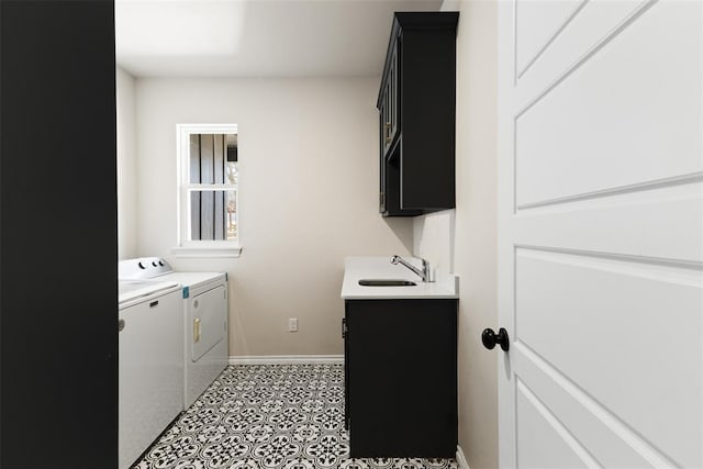 laundry area featuring cabinet space, washing machine and dryer, baseboards, and a sink