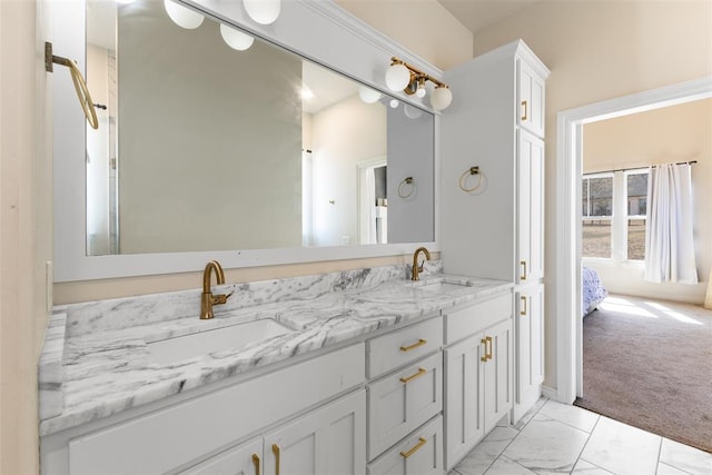 full bathroom with double vanity, marble finish floor, ensuite bathroom, and a sink