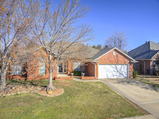 view of front facade featuring a front yard, an attached garage, brick siding, and driveway