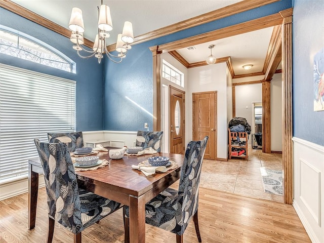 dining room with crown molding, visible vents, light wood finished floors, and a chandelier