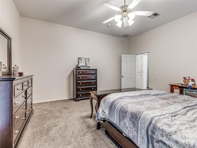 bedroom with visible vents, light carpet, baseboards, and a ceiling fan