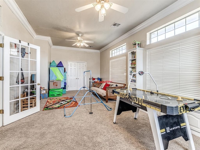 recreation room featuring visible vents, ornamental molding, and carpet flooring