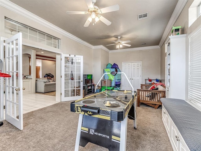 playroom featuring carpet, visible vents, ornamental molding, french doors, and tile patterned floors