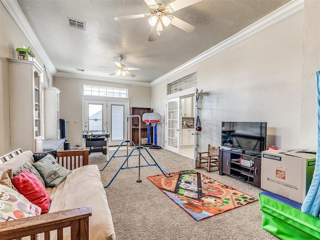 living area with visible vents, a textured ceiling, french doors, crown molding, and light colored carpet