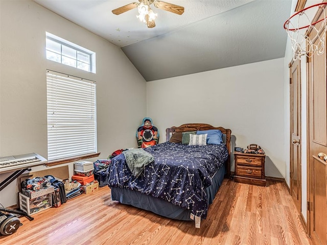 bedroom with a ceiling fan, vaulted ceiling, and wood finished floors