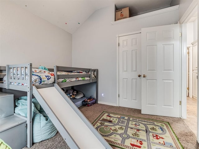 carpeted bedroom featuring a closet and lofted ceiling