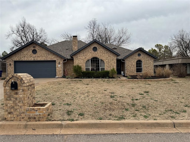 view of front of home with a shingled roof, a chimney, concrete driveway, a garage, and brick siding