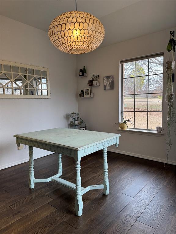 dining space featuring baseboards and wood-type flooring